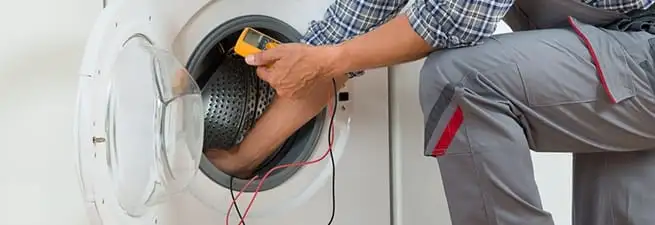 Dryer repair technician inspecting and repairing a clothes dryer in Mobile, AL