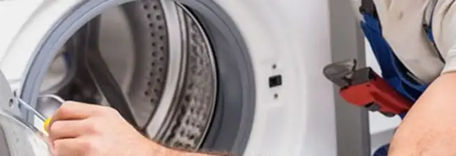 Appliance technician repairing a clothes dryer drum and internal parts in Mobile, AL