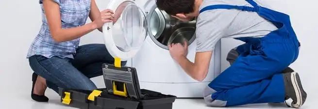 Washer repair technician inspecting a front-load washing machine with tools in Mobile, AL