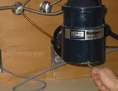 Garbage disposal repair technician tightening the mounting ring under a sink in Mobile, AL