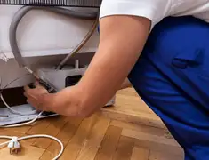 Appliance repair technician fixing refrigerator water line and connections in Mobile, AL