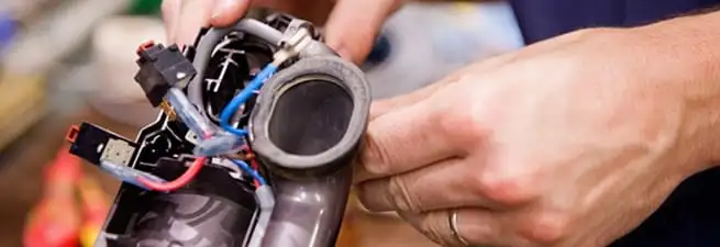 Vacuum repair technician reconnecting wiring and components in Mobile, AL
