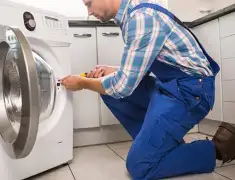 Washing machine repair technician servicing a front-load washer in Mobile, AL