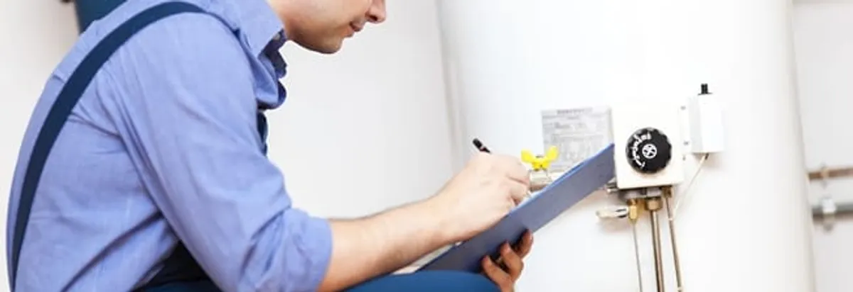 Water heater repair technician inspecting the unit and recording service notes in Mobile, AL