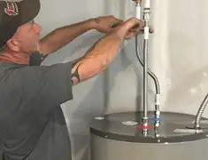 Water heater repair technician tightening supply line connections in Mobile, AL